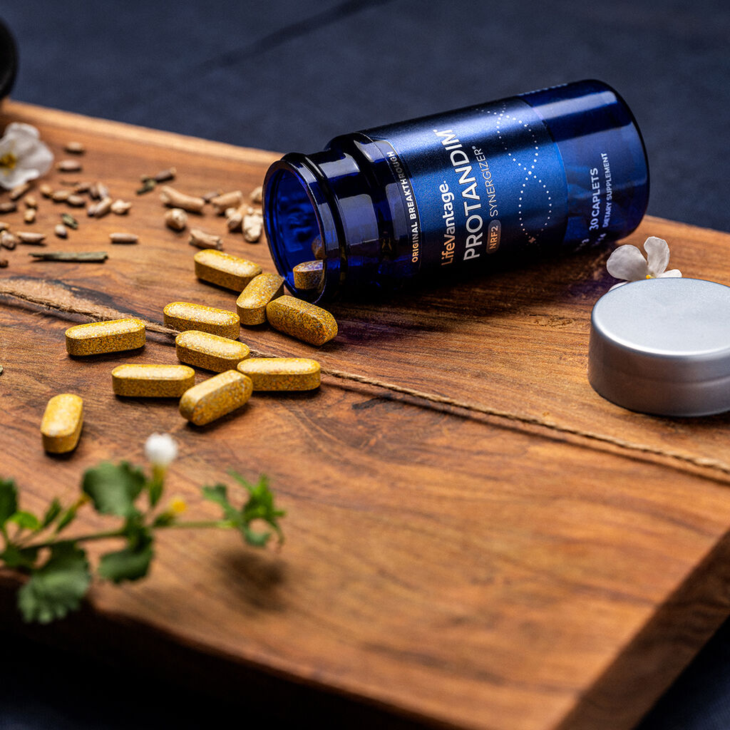 LifeVantage Protandim NRF2 Synergizer supplement bottle with caplets on a wooden board